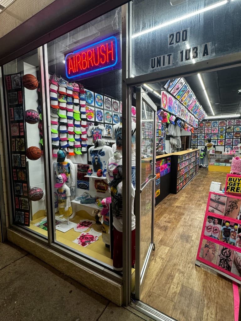 Kreations Airbrush and Henna Tattoos shop storefront at night
